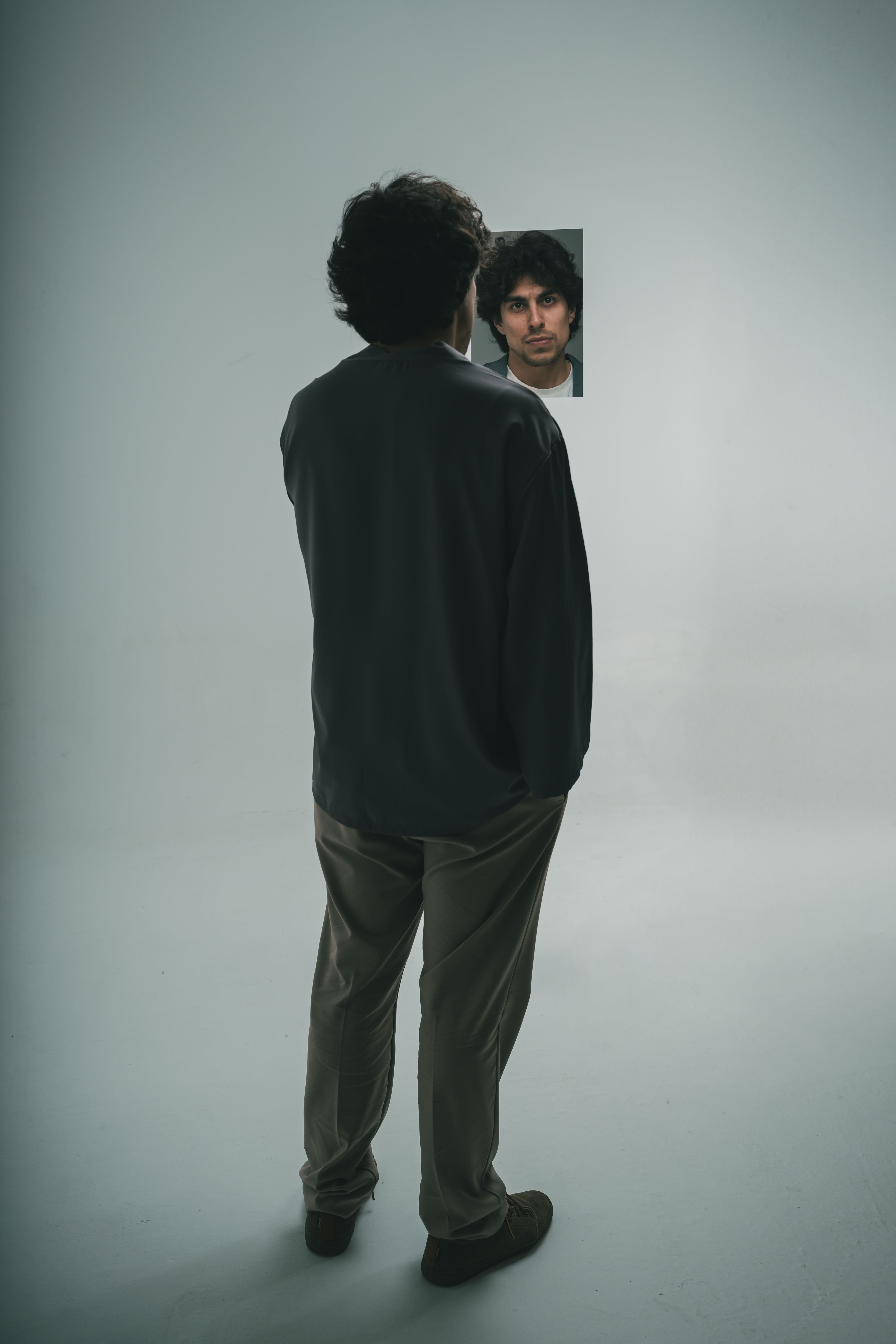 Reflejo del artista Andrés Iwasaki en un espejo de agua sobre la arena, evocando el concepto de Zulviem.